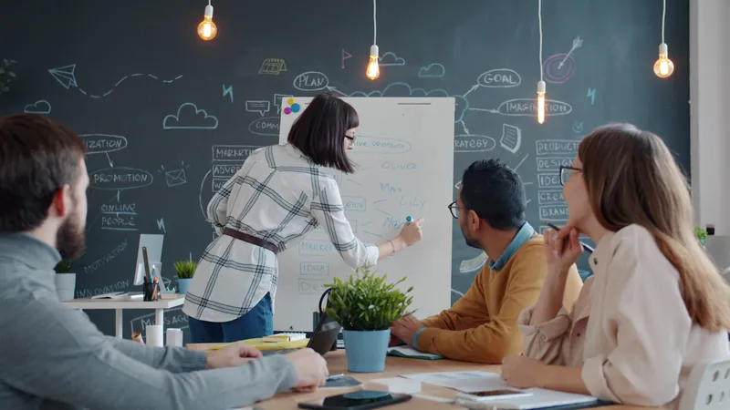 Équipe collaborant autour d'un tableau blanc dans un bureau lumineux