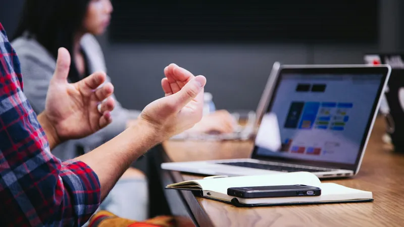 Équipe d'une PME réunie autour d'un ordinateur portable en réunion de travail