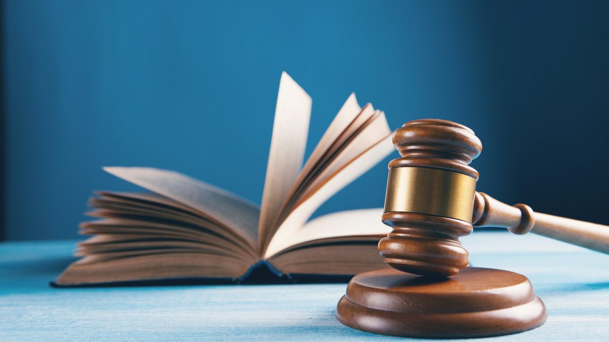 Un marteau de juge et un livre ouvert — reglementation et conformite