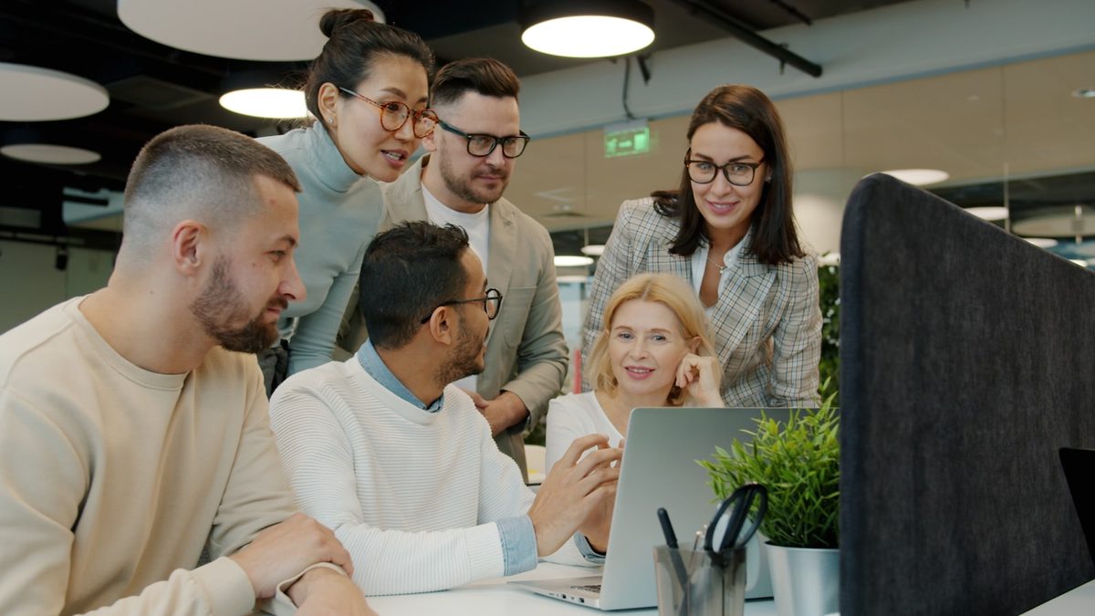 Une equipe collabore autour d'un ordinateur portable dans un bureau