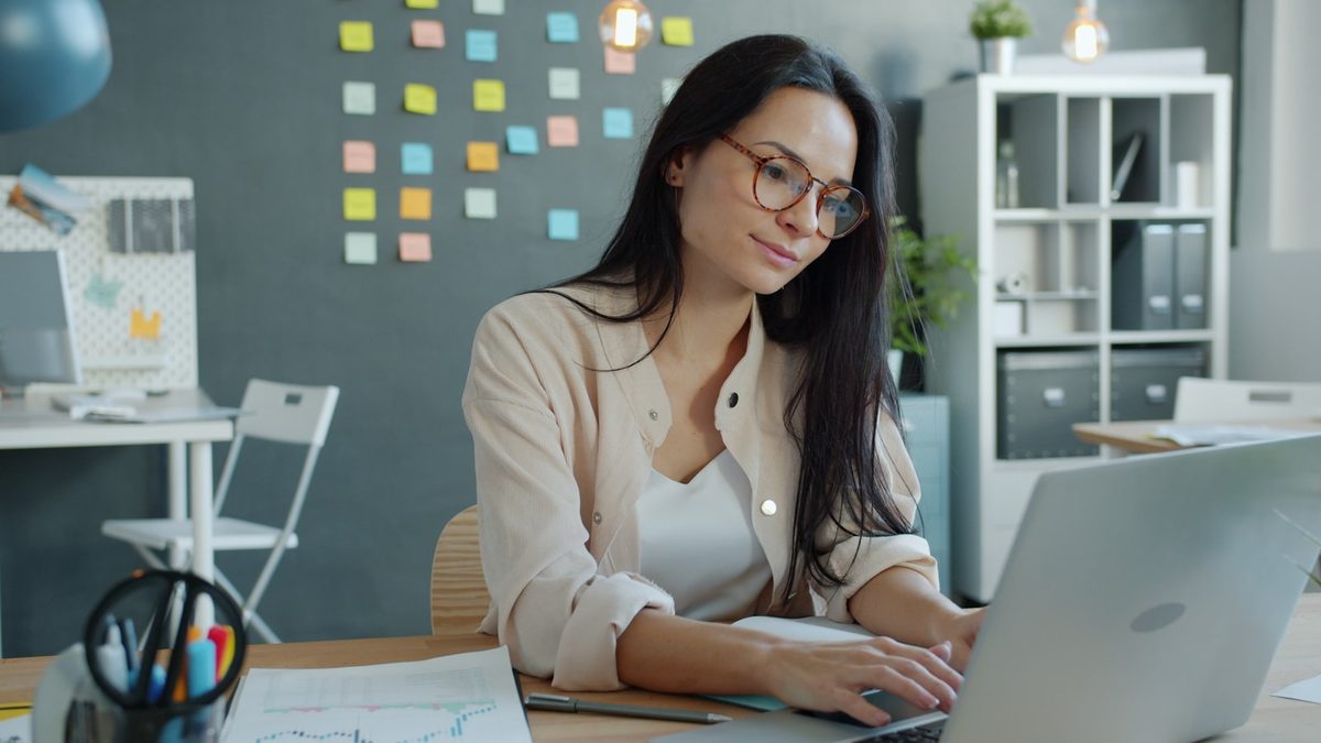 Une professionnelle travaille sur un ordinateur portable dans un bureau moderne