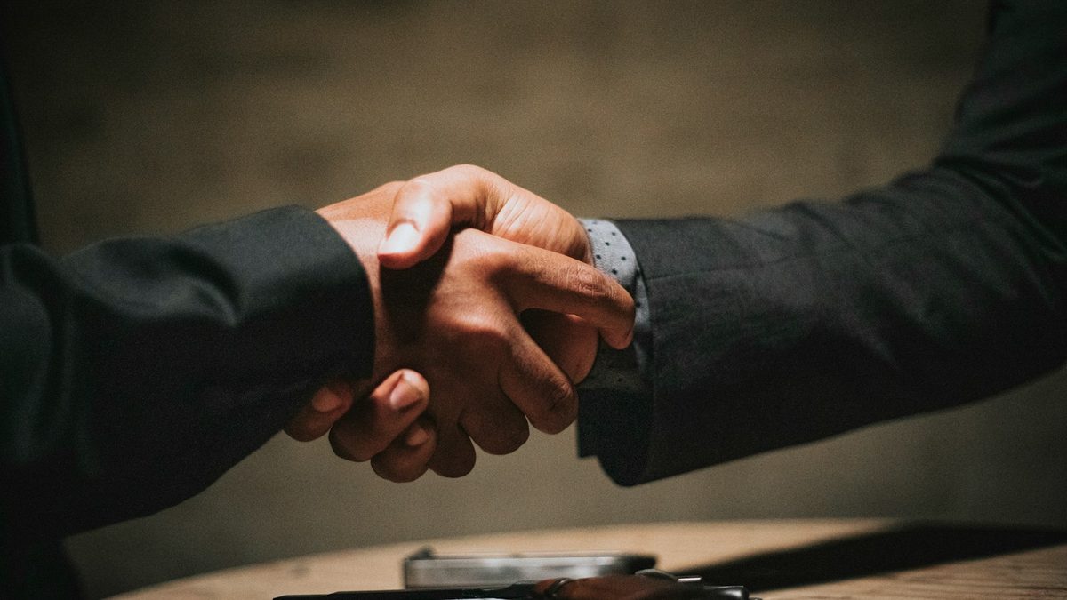 Poignee de main professionnelle au-dessus d'une table — recrutement de cadres