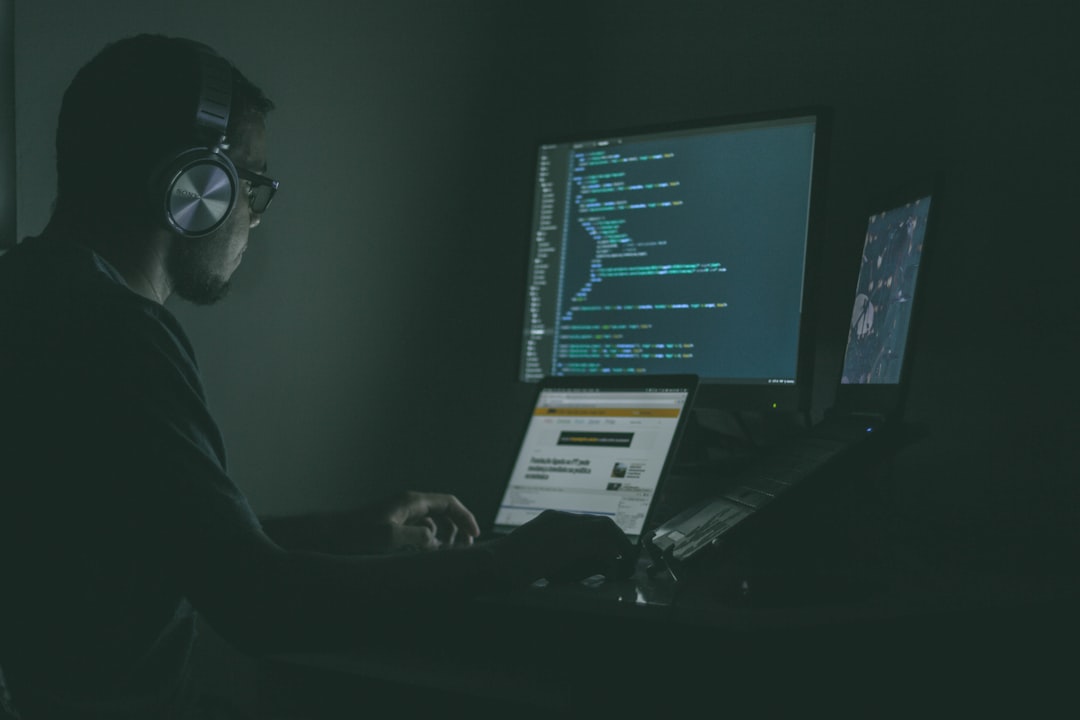 Expert en cybersécurité analysant des données sur plusieurs écrans dans un environnement professionnel